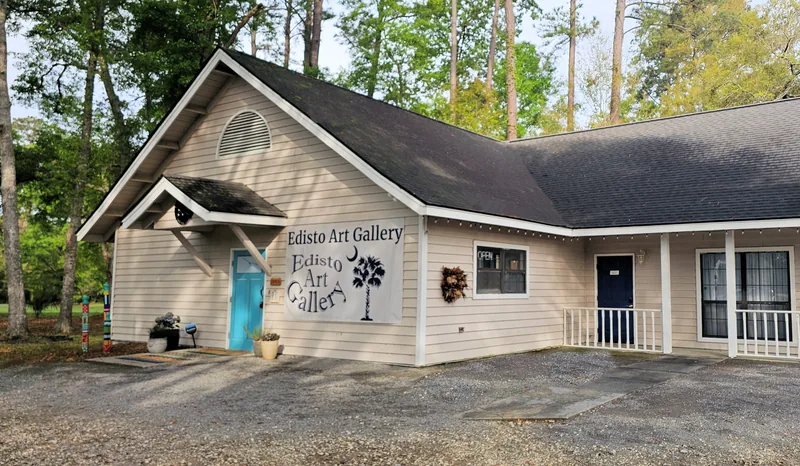 The front of the Edisto Art Gallery building, with its sign and teal door